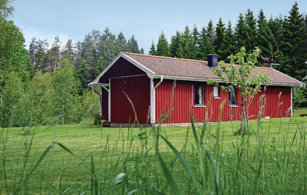 a red barn in the middle of a field at Nice Home In Vaggeryd With 2 Bedrooms And Sauna in Hok