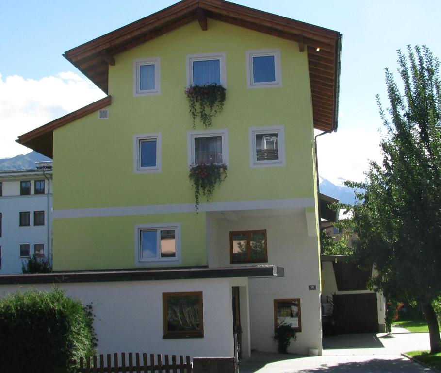 uma casa amarela e branca com duas janelas em Haus Schmidl em Zell am See