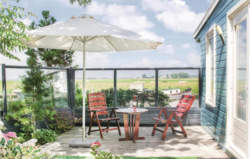 eine Terrasse mit einem Tisch, Stühlen und einem Sonnenschirm in der Unterkunft Beautiful Home In Lauwerzijl With Outdoor Swimming Pool in Lauwerzijl