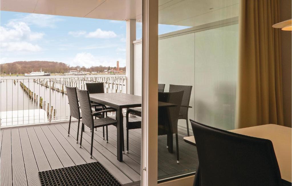 a balcony with a table and chairs and a view of the water at Promenadenvilla in Priwall