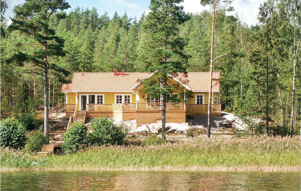 a house in the woods next to a body of water at 5 Bedroom Awesome Home In Segmon in Kangerud