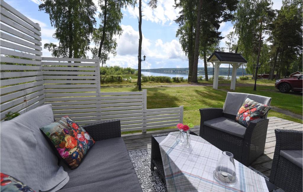 um pátio com uma mesa e cadeiras e vista para a água em Stunning Home In Hjo With House Sea View em Hjo
