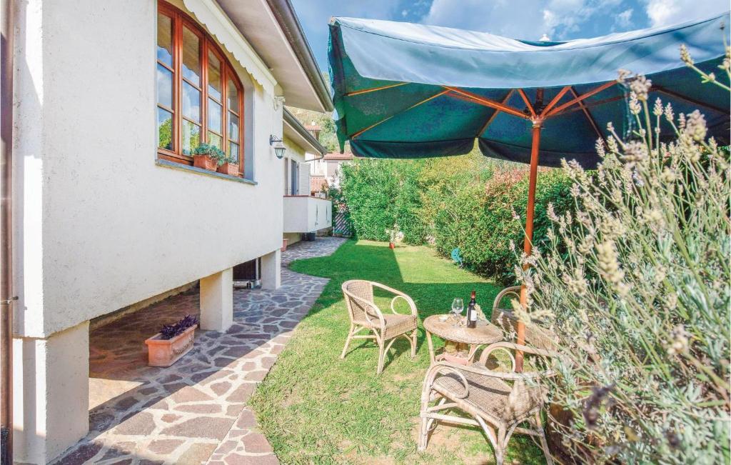 patio ze stołem, krzesłami i parasolem w obiekcie Awesome Home In Camaiore -lu- With Kitchen w mieście Camaiore