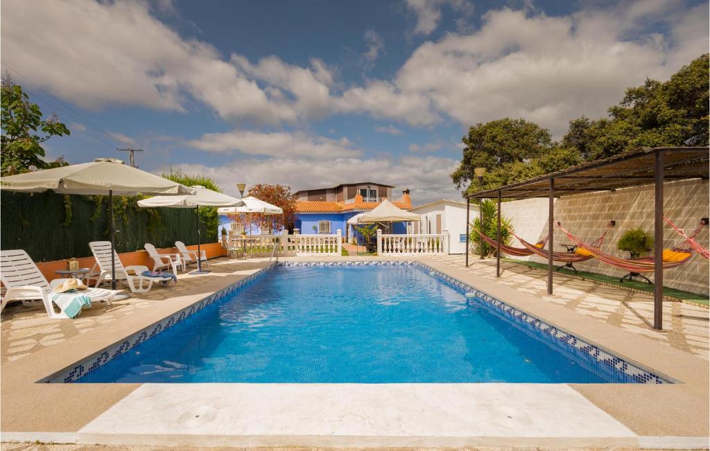 einen Pool mit Hängematte und ein Haus in der Unterkunft Gorgeous Home In Guillena With Outdoor Swimming Pool in Guillena