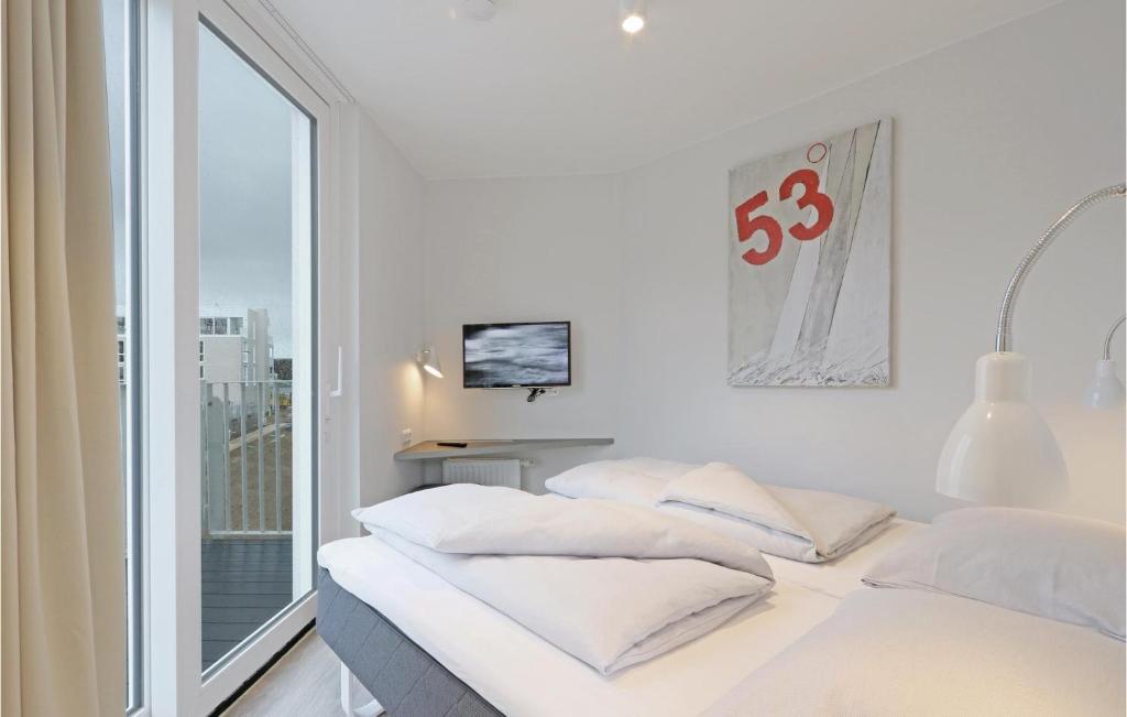 2 camas en una habitación blanca con ventana en Dnenvilla, en Travemünde