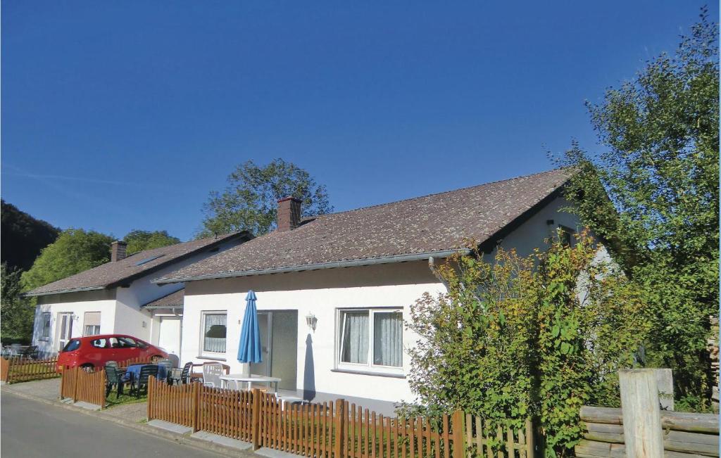 une maison blanche avec une clôture et un parapluie bleu dans l'établissement Awesome Home In Ltzkampen With Wifi, à Welchenhausen