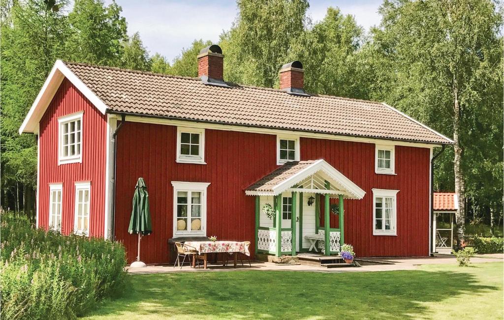 a red house with a table in front of it at Amazing home in Unnaryd with 2 Bedrooms, Sauna and WiFi in Unnaryd