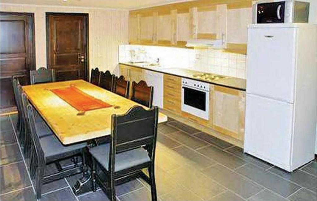 Amazing Apartment In Hemsedal With House A Mountain View في هيمسيدال: مطبخ مع طاولة وثلاجة بيضاء