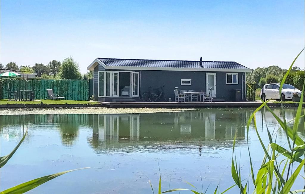 a tiny house sitting next to a body of water at Amazing Home In Molenschot With House Sea View in Molenschot