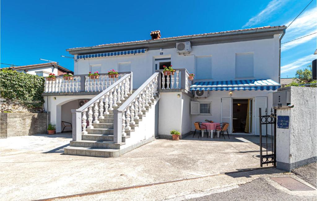 een wit huis met een trap en een patio bij Pet Friendly Apartment In Jadranovo With Wifi in Jadranovo