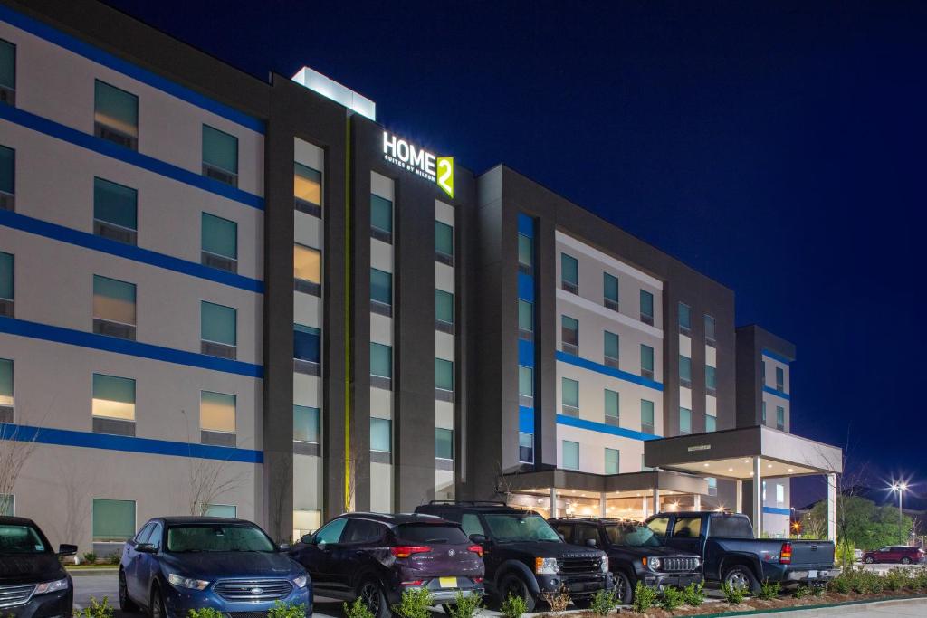 Home2 Suites By Hilton Baton Rouge Citiplace في باتون روج: فندق فيه سيارات تقف امامه