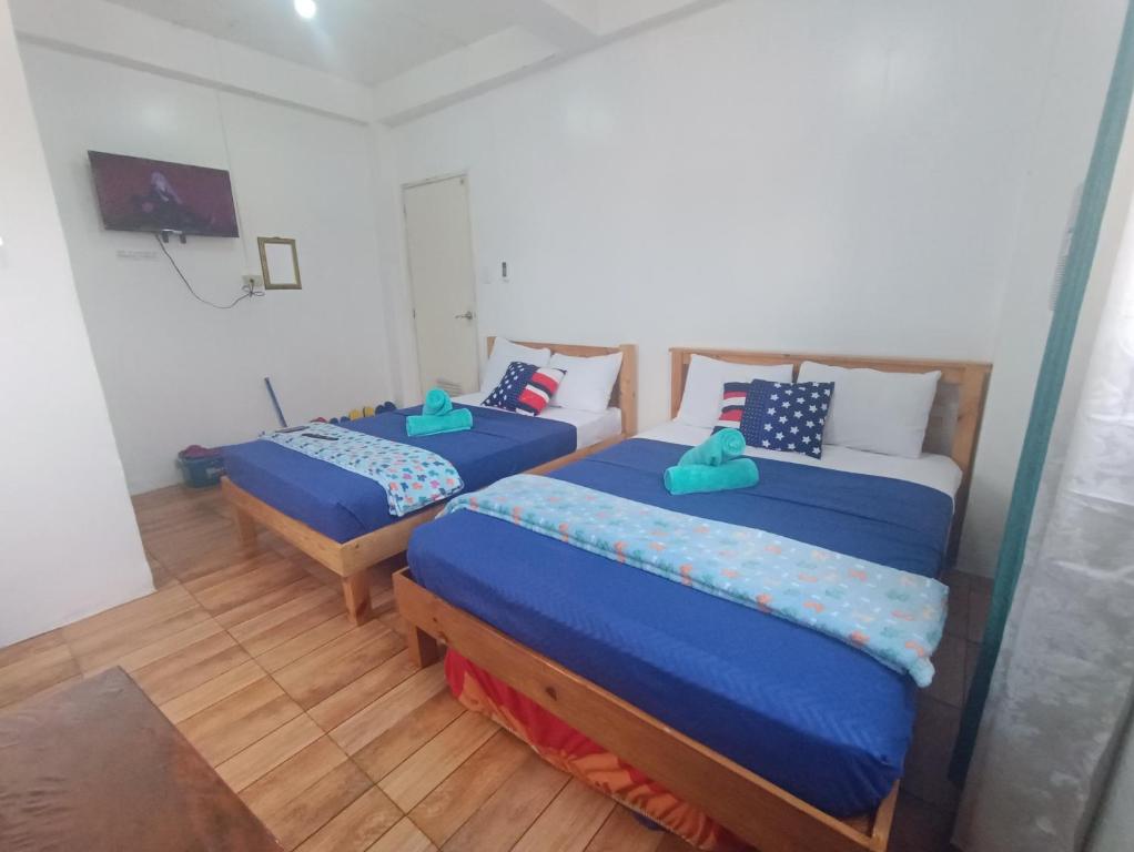 um quarto com 2 camas e lençóis azuis em MJ Home em Manila