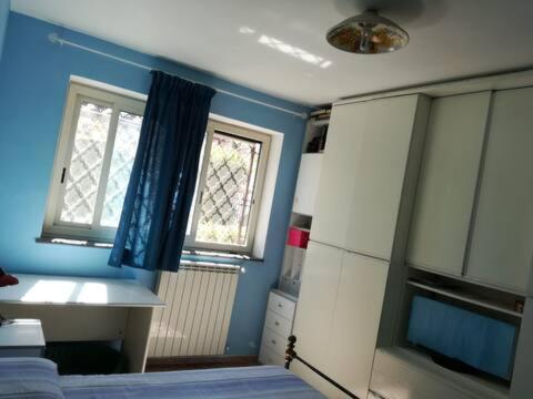 - une chambre avec des murs bleus, un lit et une fenêtre dans l'établissement DOG HOUSE FROM POMPEI-AMALFI, à SantʼAntonio Abate