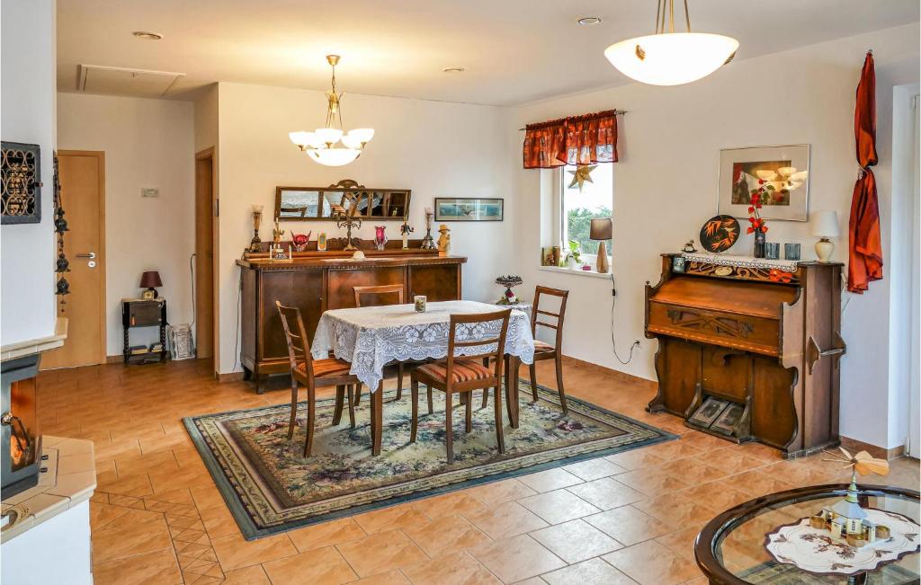 a dining room with a table and a piano at Beautiful Home In Brnlos With Wifi 