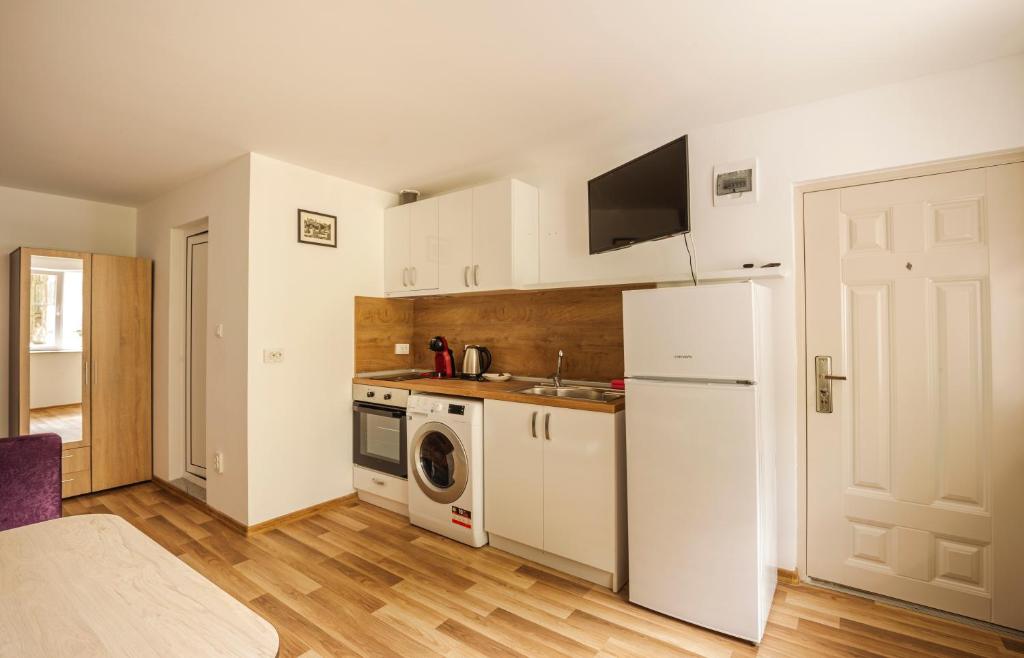 a kitchen with a white refrigerator and a microwave at Apartment Cozy Home 3 in Ruse