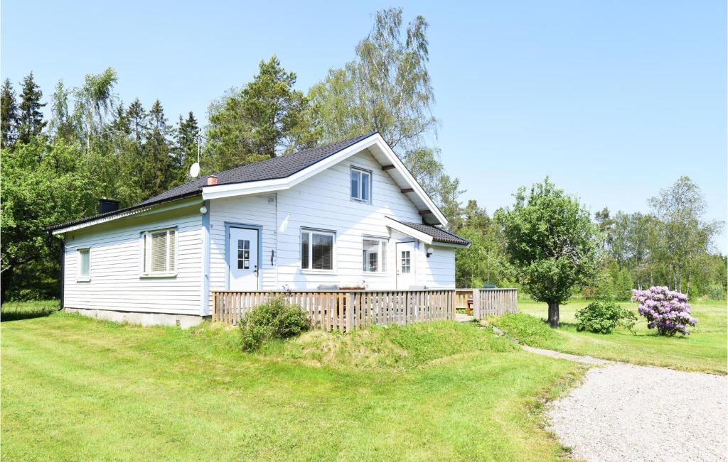 a white house with a fence in a yard at 3 Bedroom Amazing Home In Vnersborg in Vänersborg