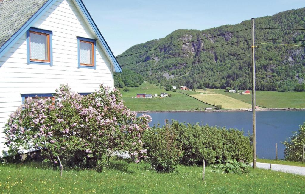 a white house with a lake and a mountain at Awesome Home In Srbvg With House A Mountain View in Sandnes