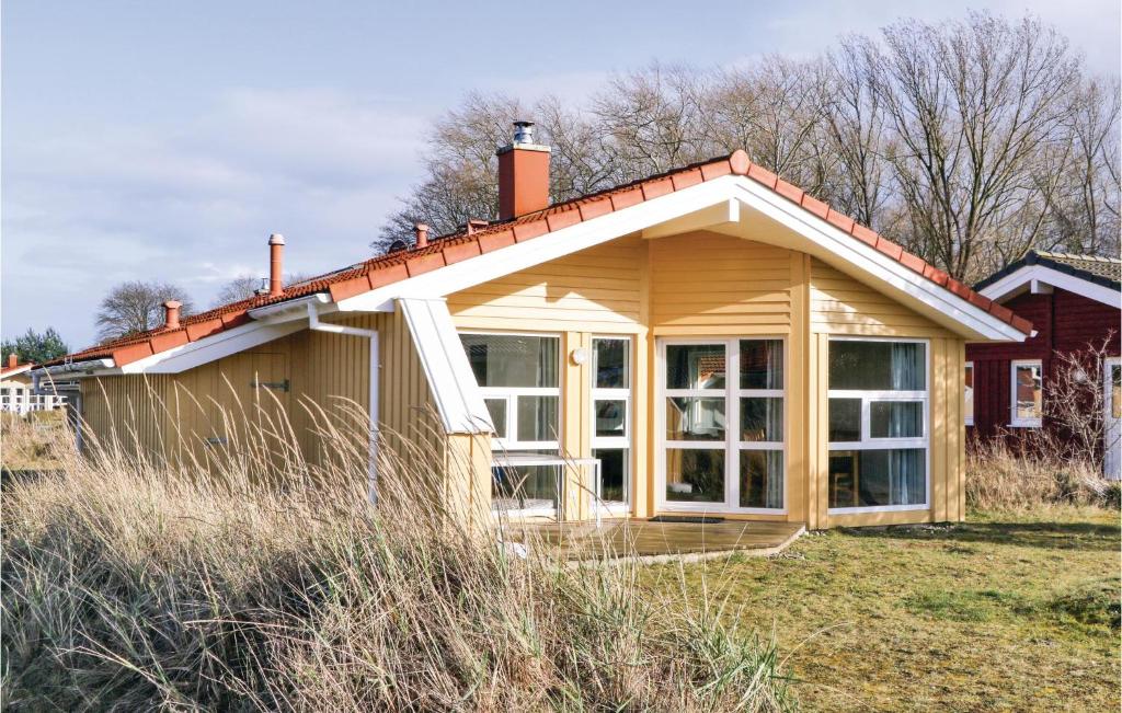 a house with a large window in a field at Dünenpark 16 - Dorf 6 in Priwall