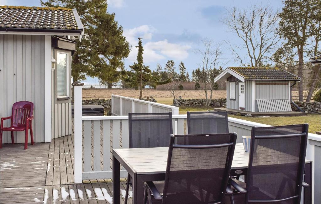 une terrasse en bois avec des chaises et une table sur une maison dans l'établissement Awesome Home In Lttorp With Wifi, à Löttorp