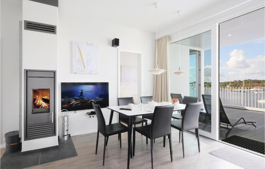ein Esszimmer mit Tisch und Stühlen und einem Fernseher in der Unterkunft Priwallpromenade 2, Whg 11 in Travemünde