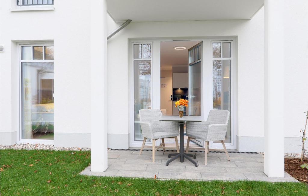 d'une terrasse avec une table et des chaises devant une maison blanche. dans l'établissement Baltischer Hof Apartment 19, à Boltenhagen