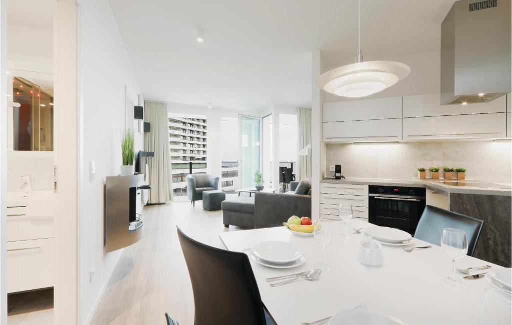 a kitchen and living room with a white table and chairs at Highend Travemünde - Whg 407 in Travemünde