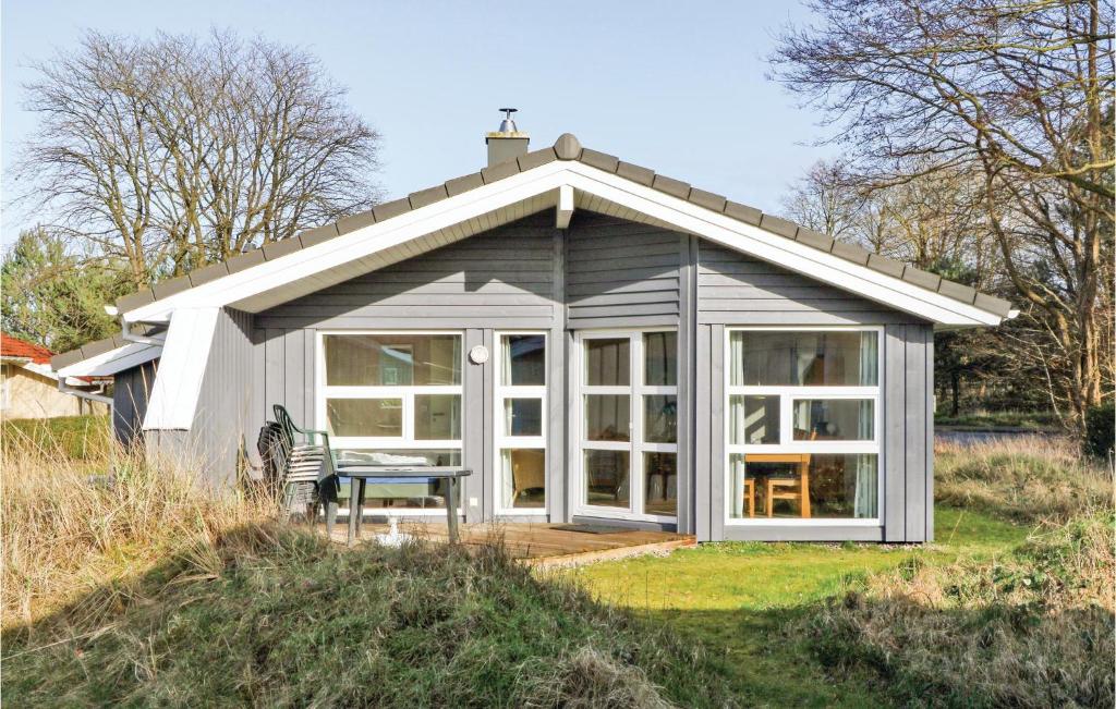 a small white cottage with a table in front of it at Dünenpark 22 - Dorf 6 in Priwall