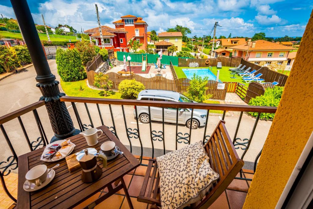 Un balcón con mesa y sillas y una piscina. en Apartamentos Cudillero, en Cudillero