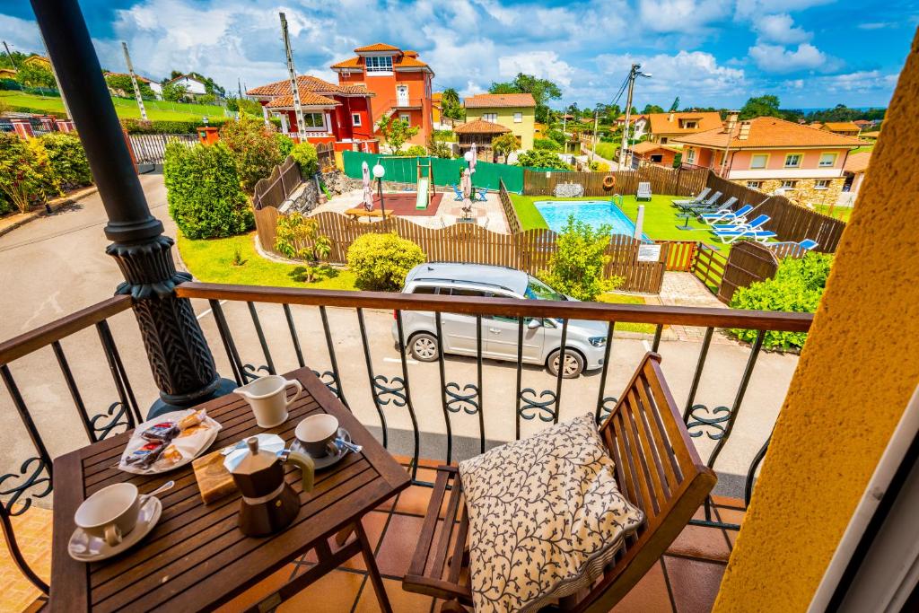 a balcony with a table and chairs and a pool at Apartamentos Cudillero in Cudillero