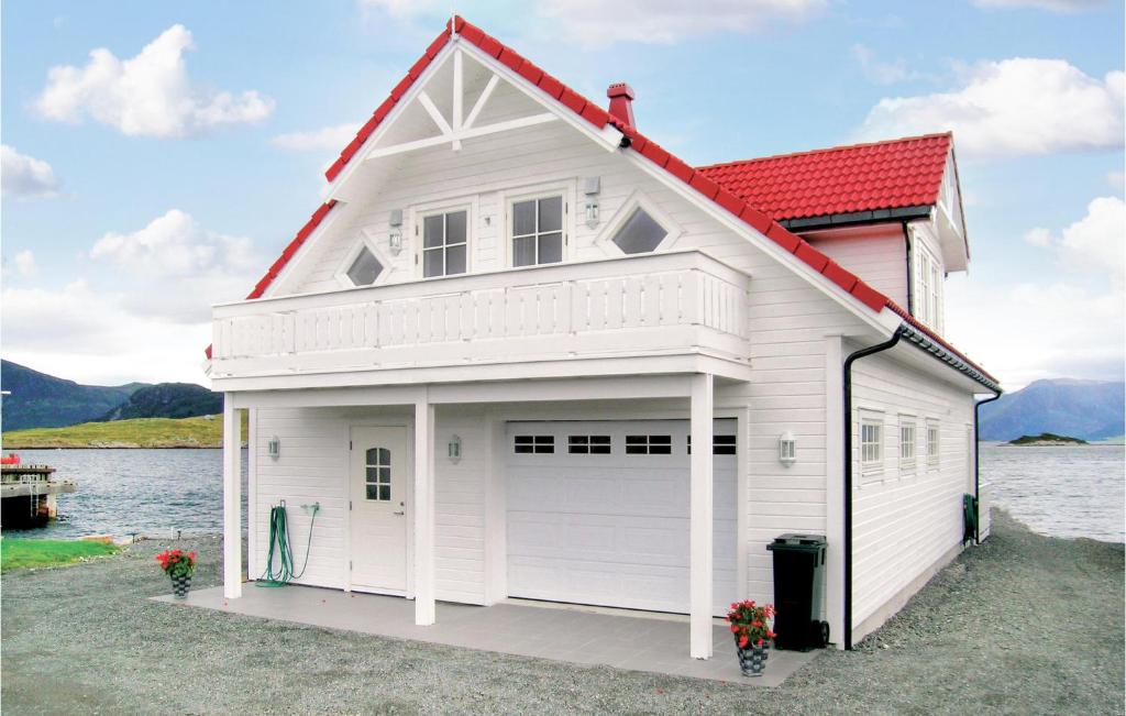 une maison blanche avec un toit rouge et un garage dans l'établissement Sandshamn, à Sandshamn