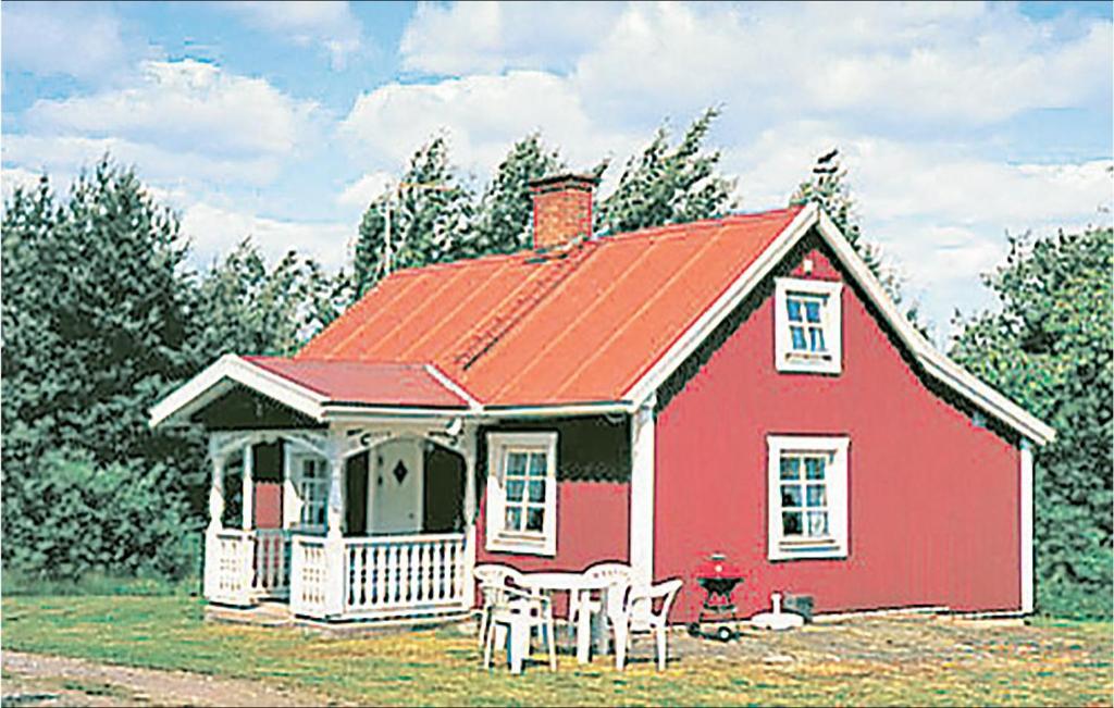 une maison rouge avec une table et des chaises devant elle dans l'établissement Stunning Home In Kristdala With Kitchen, à Malghult