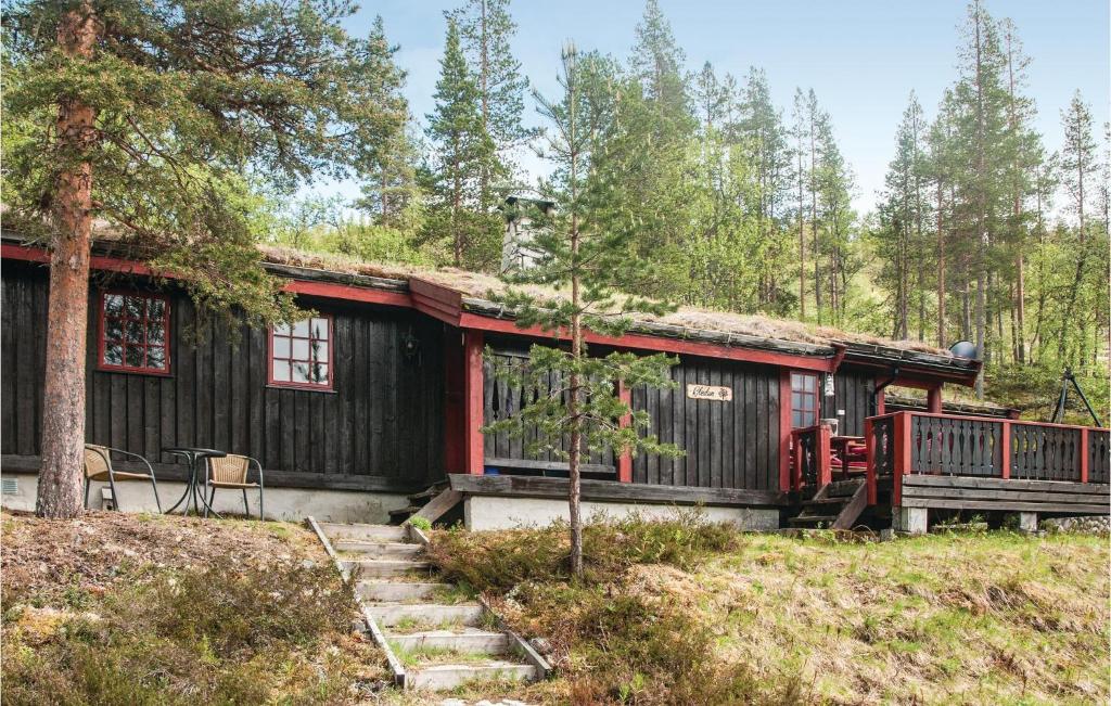 eine Hütte im Wald mit einer Veranda und einer Terrasse in der Unterkunft Four-Bedroom Holiday Home In Rendalen in Rendalen