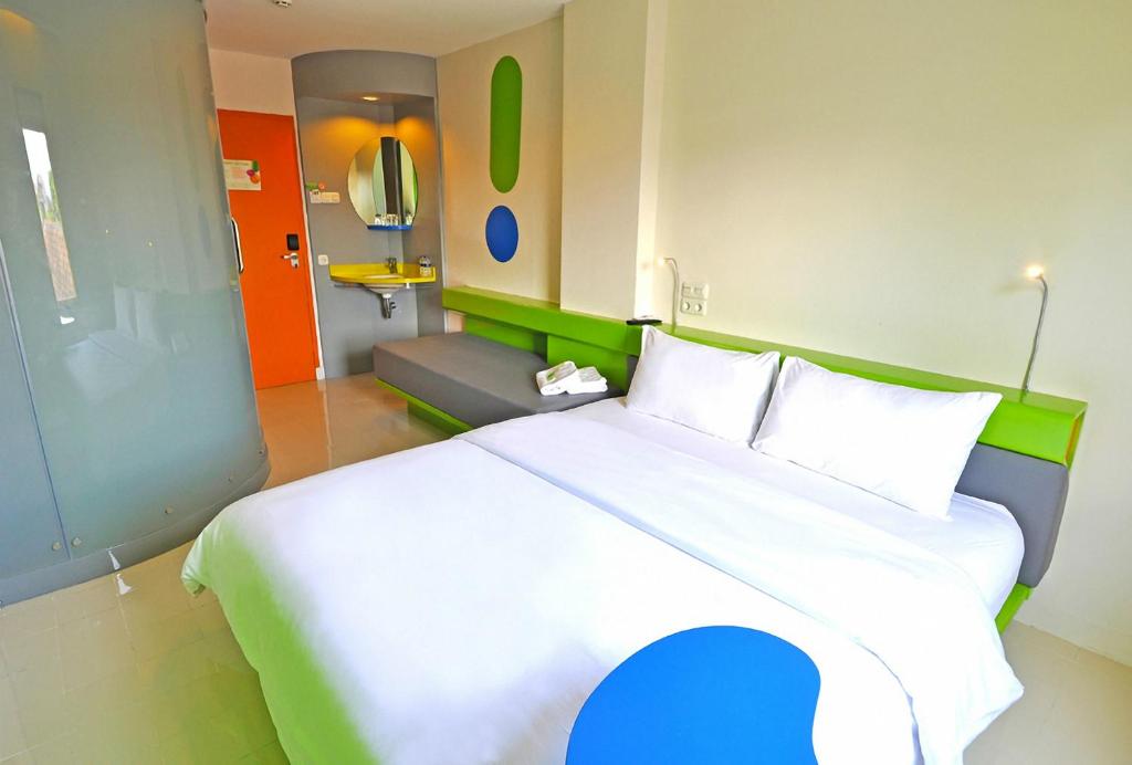 a bedroom with a large bed and a room with a couch at POP! Hotel Airport Jakarta in Tangerang