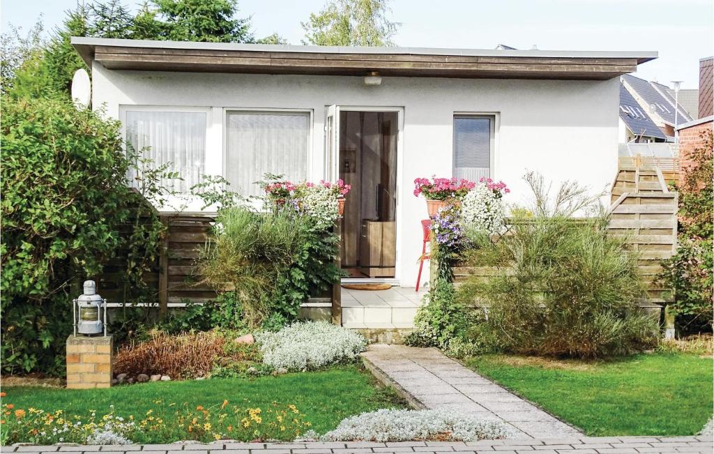 a small white house with flowers in the yard at Awesome Home In Insel Poel in Insel Poel
