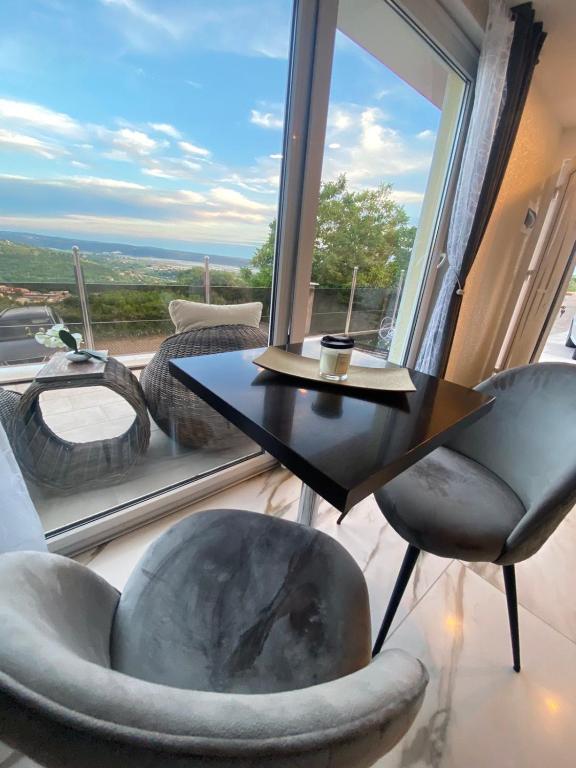 a room with a table and chairs and a large window at Apartma Hill Portorose in Portorož