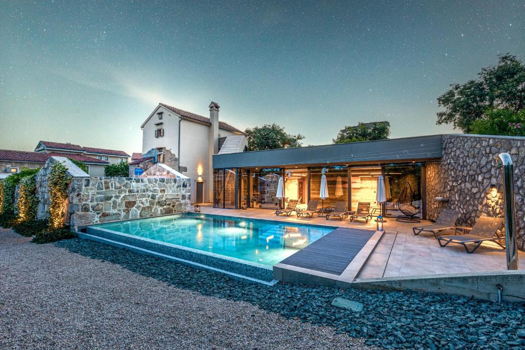 a house with a swimming pool in front of a house at Luxury Jerini Estate in Krk