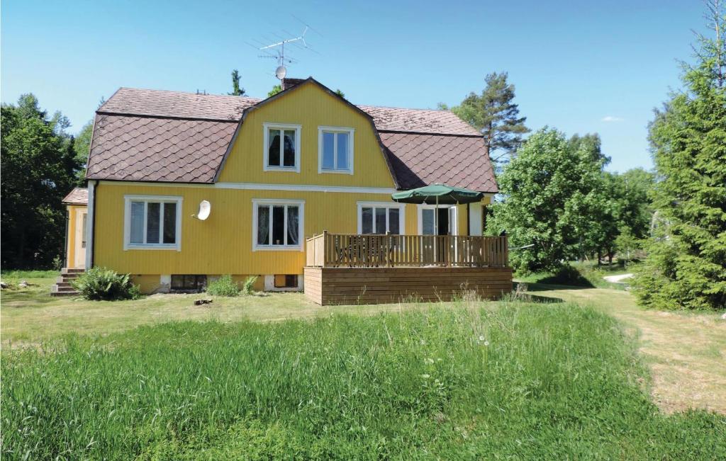 ein gelbes Haus mit einer Terrasse im Hof in der Unterkunft Nice Home In Markaryd With Kitchen in Västra Tansjö