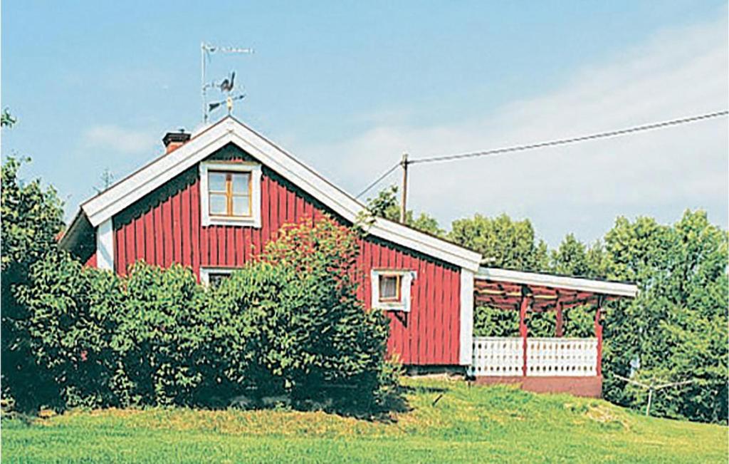 una casa roja sentada en la parte superior de un exuberante campo verde en Lovely Home In Trans With Kitchen, en Sundhultsbrunn