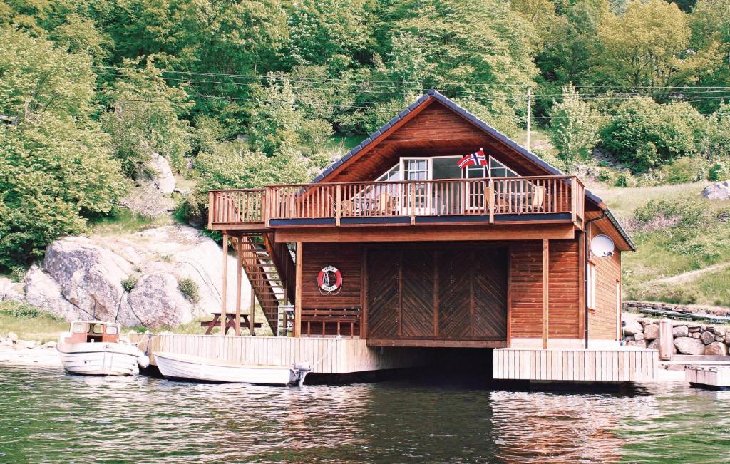 a house on the water with two boats in it at Amazing Home In Farsund With Wifi in Farsund