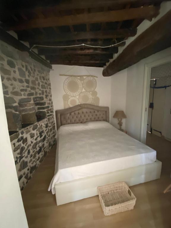 ein Schlafzimmer mit einem Bett mit einer Steinmauer in der Unterkunft La Torre saracena di Tellaro - ConfirentHouse in Tellaro