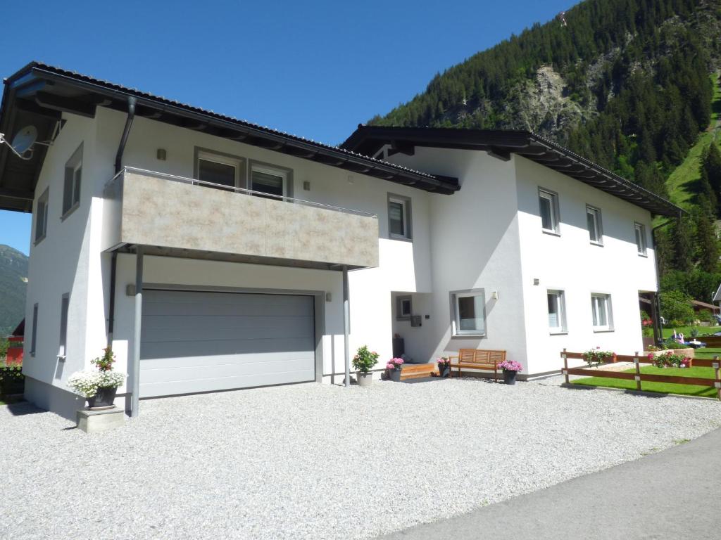 a large white house with a large garage at Alpenchalet Breitspitz in Partenen