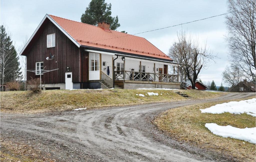 ein Haus mit rotem Dach auf einer unbefestigten Straße in der Unterkunft 2 Bedroom Beautiful Home In Gunnarskog in Gunnarskog