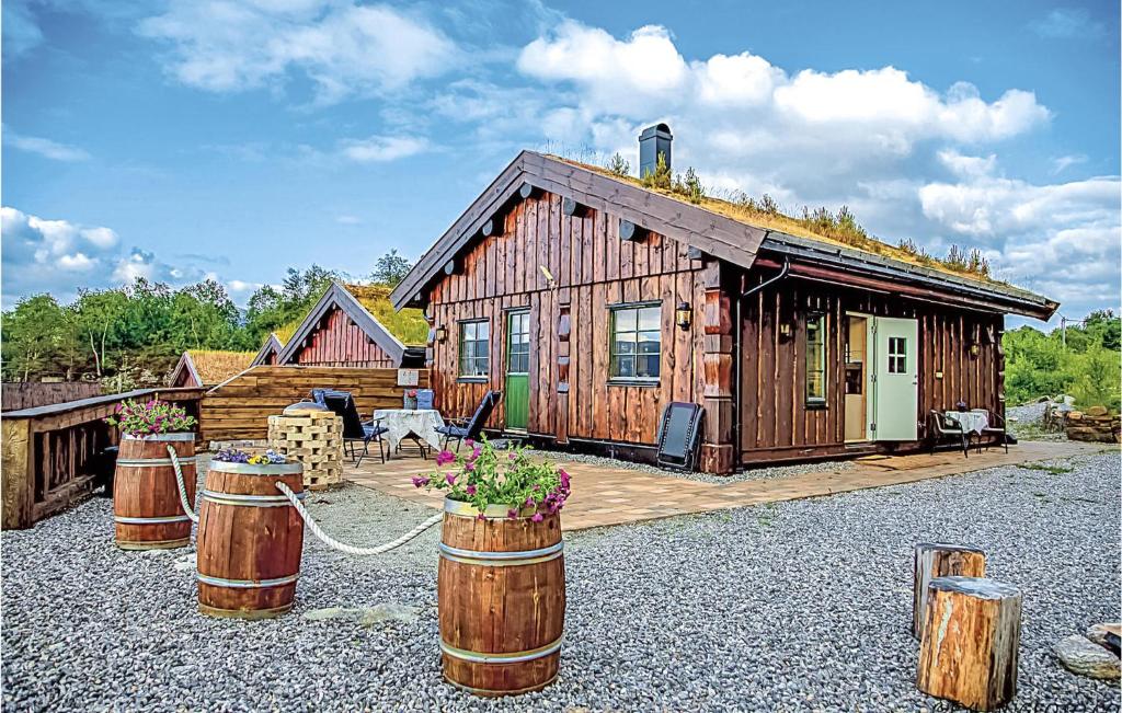 a log cabin with barrels in front of it at Hytte 19 in Ikornnes