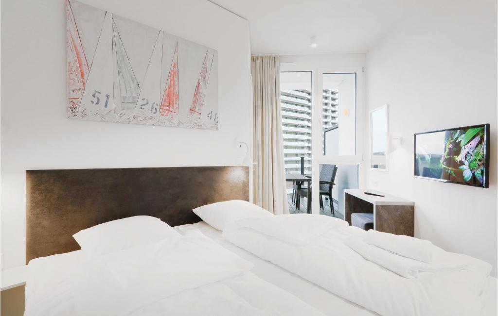 トラフェミュンデにあるNice Apartment In Lbeck Travemnde With 2 Bedrooms, Sauna And Wifiの白いベッドルーム(白いベッド2台、テーブル付)