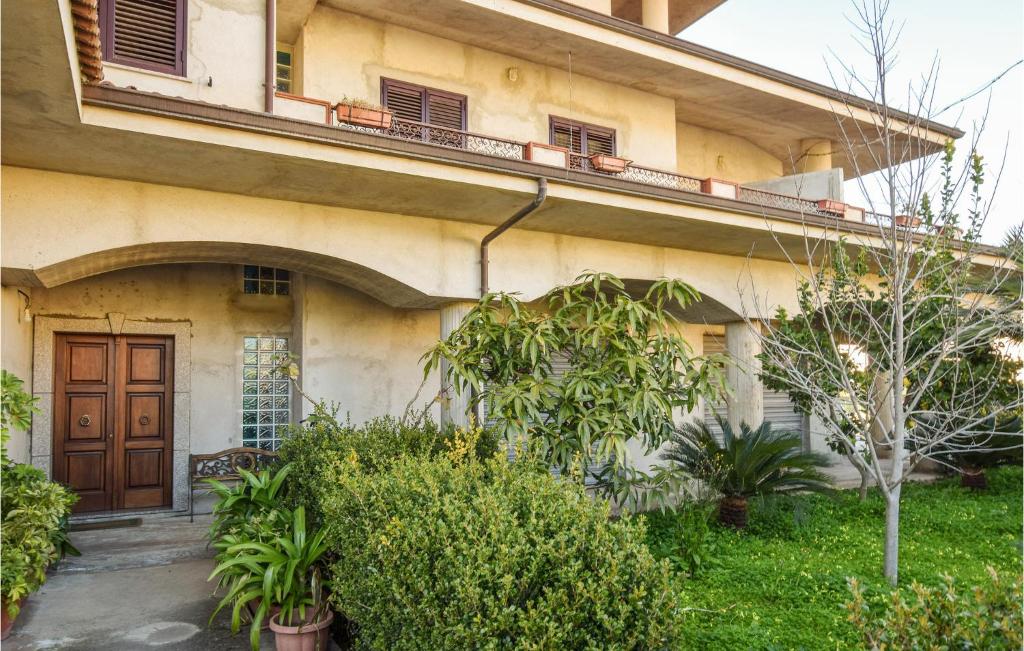 un edificio con una puerta de madera y algunas plantas en Gorgeous Apartment In Ricadi With Wifi, en Ricadi