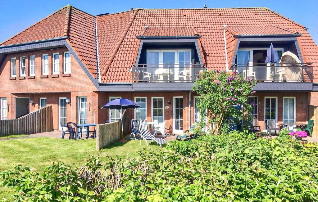 a brick house with a table and chairs in a yard at Stunning Apartment In Friedrichskoog Spitze With Kitchen in Friedrichskoog-Spitze