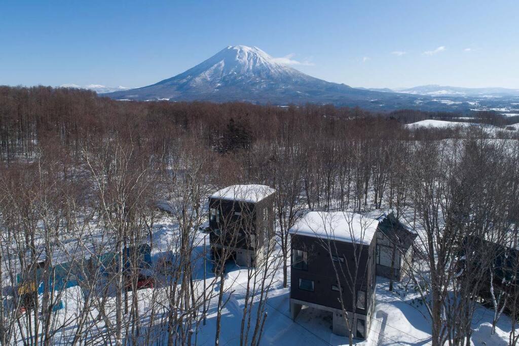 a snow covered mountain in the distance with two huts at Yuki no Taki 2 in Niseko