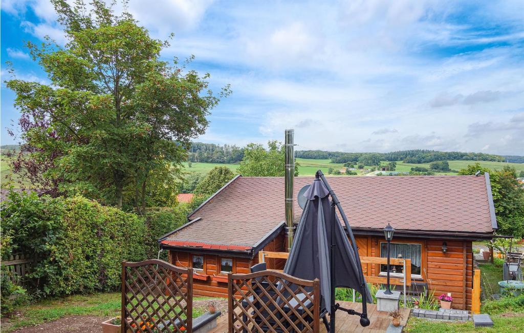 une maison en bois avec un parasol sur un balcon dans l'établissement Beautiful Home In Diemelsee With House A Panoramic View, à Diemelsee