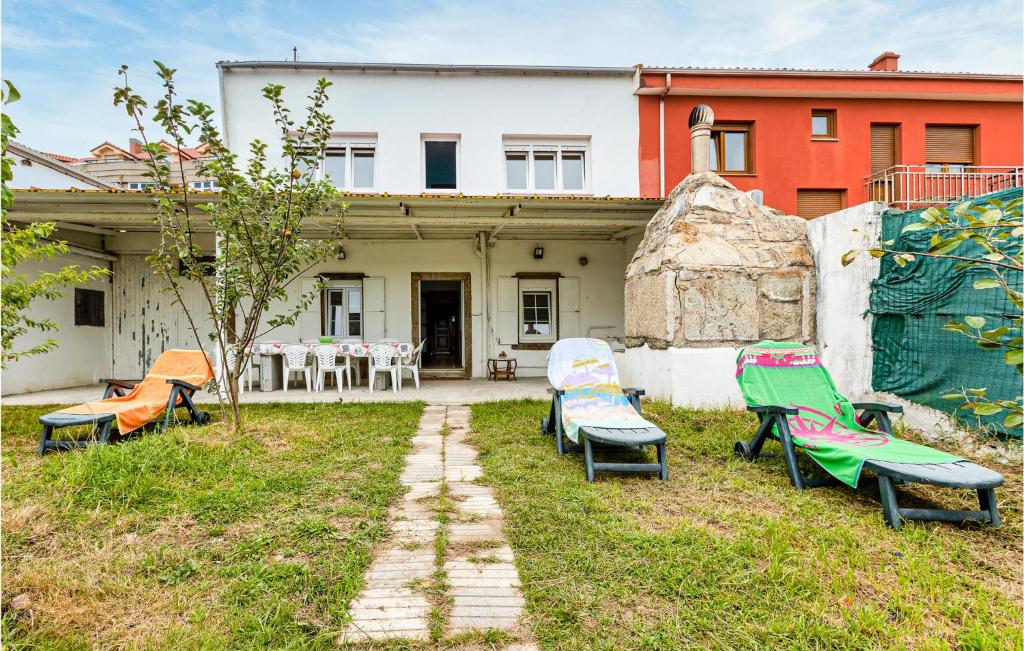 a group of chairs in the yard of a house at Nice Home In Fisterra With 7 Bedrooms And Wifi in Fisterra