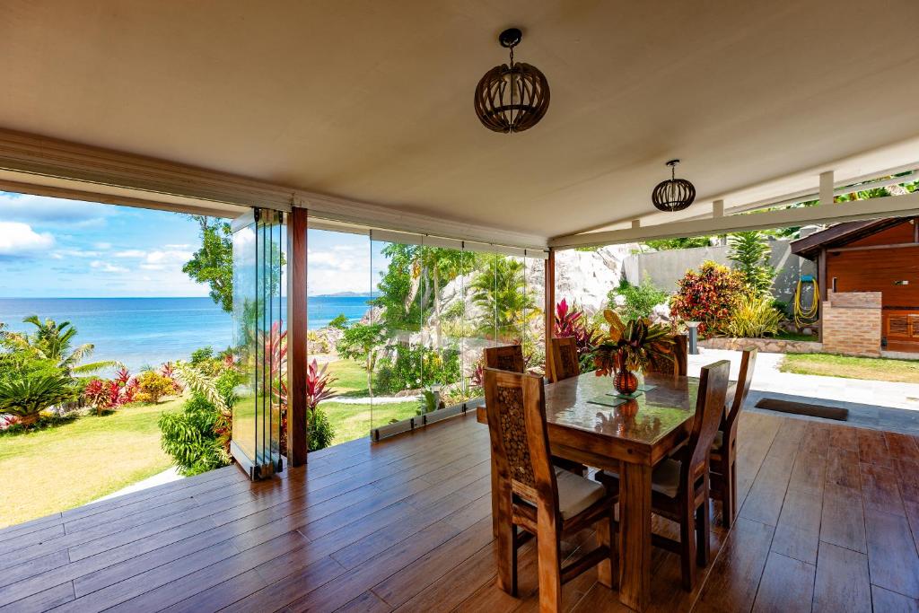uma sala de jantar com uma mesa e vista para o oceano em Cote Mer villa em Baie Sainte Anne